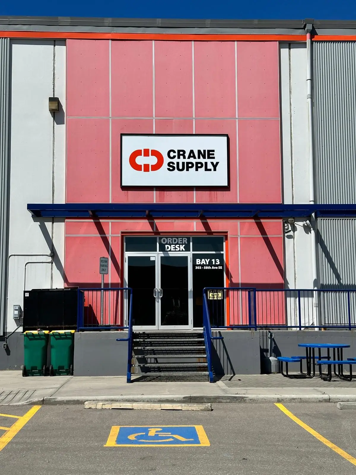An illuminated exterior building sign mounted on the fascia of a Calgary industrial supply warehouse