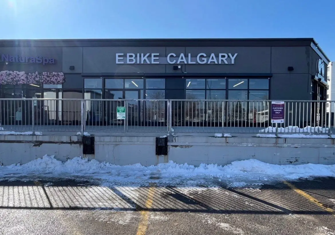 Wide-spaced channel letters running along the dark upper fascia of a Calgary retail storefront