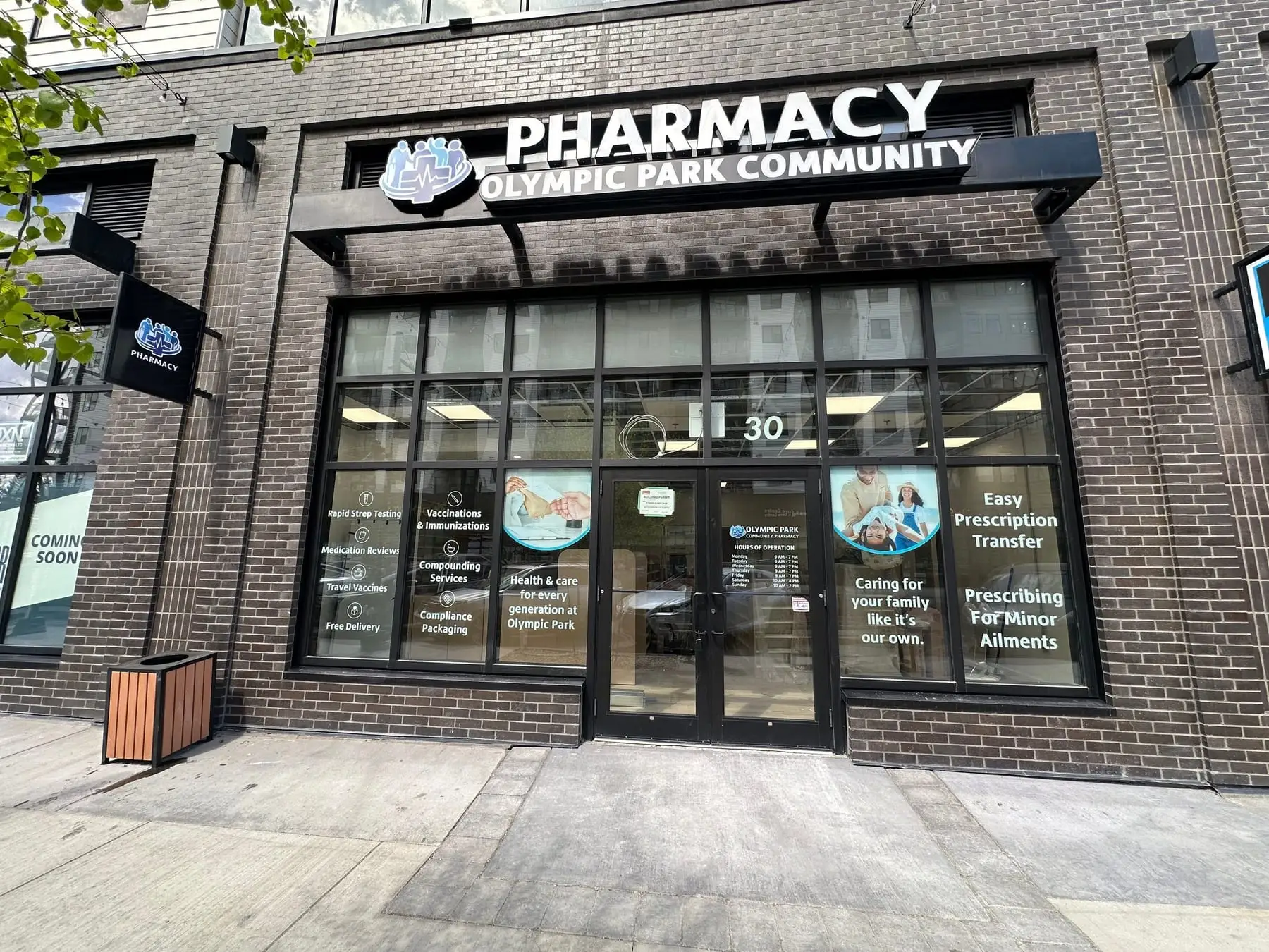 Channel letters and a logo mounted along the dark fascia above a pharmacy in a Calgary brick retail building