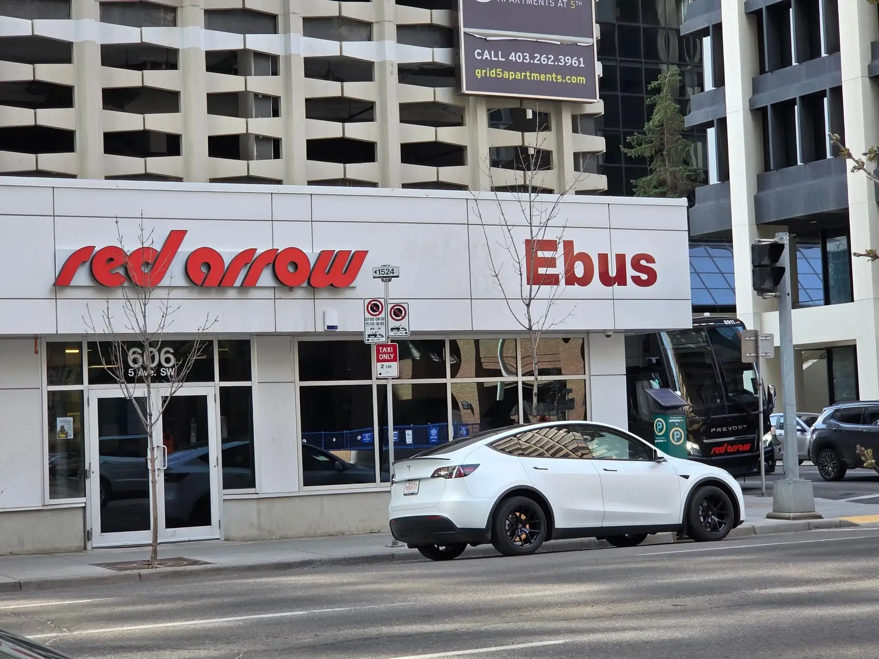 Red dimensional lettering on the white fascia of a downtown Calgary building at street level