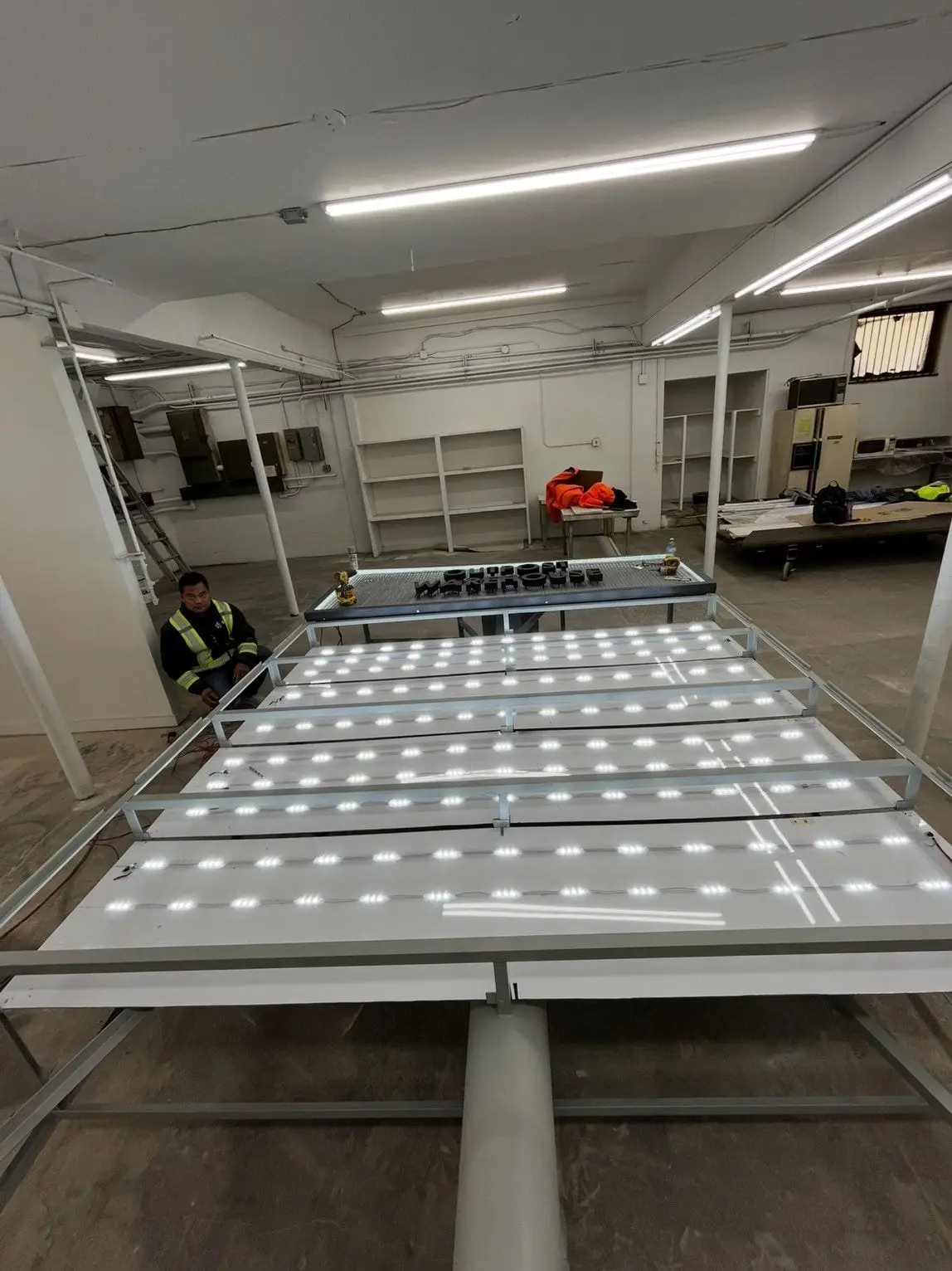 Illuminated sign panels being assembled on the bench inside the FASTSIGNS Northeast Calgary production facility